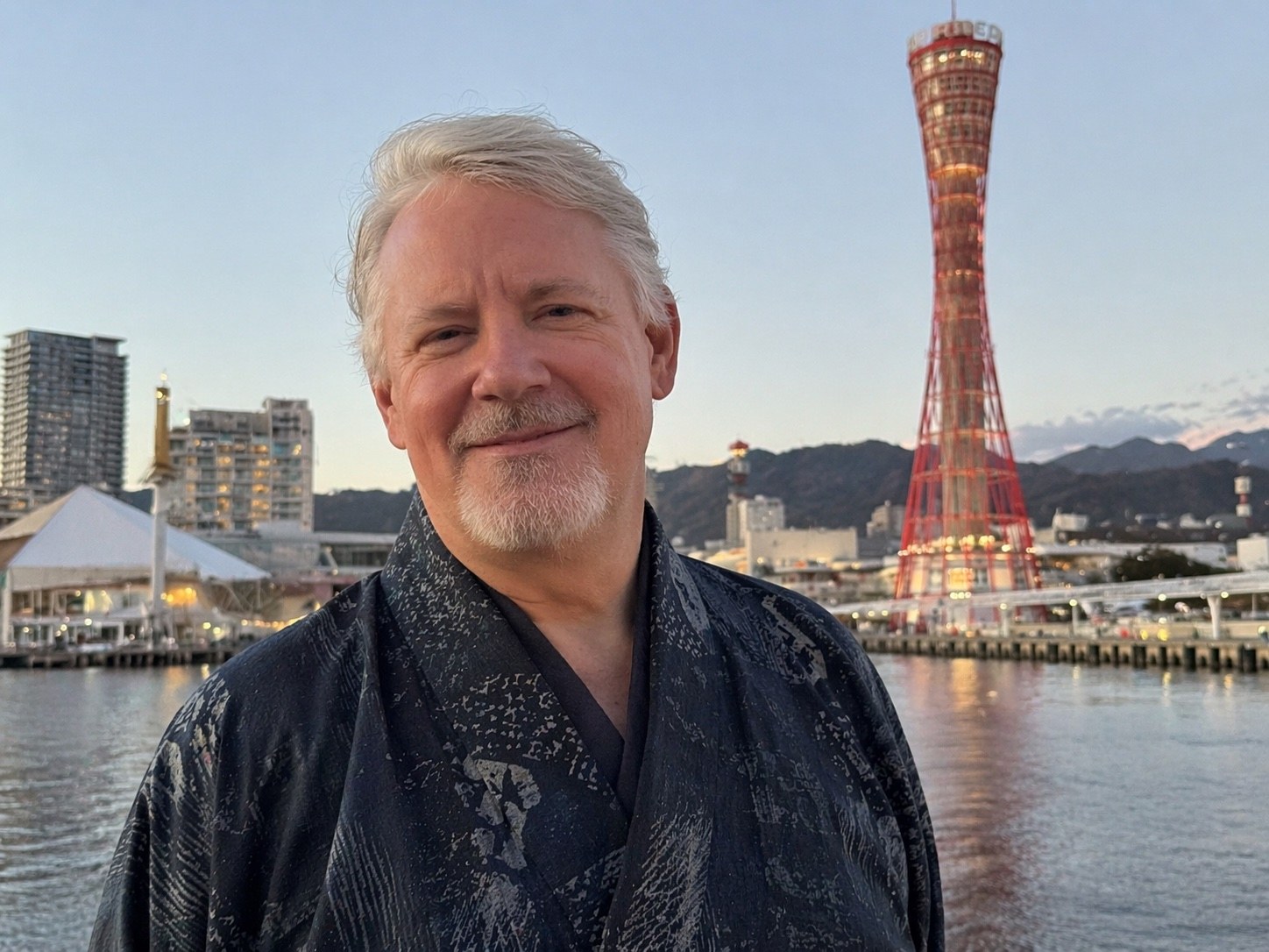 Shawn Dolven at Kobe harbor, with Kobe Port Tower in background